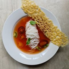 A picture of Tomato broth with vermicelli noodles and parmesan crisp.