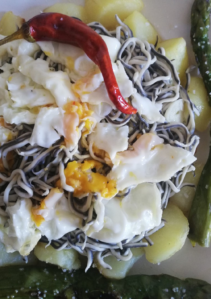 Una foto de Huevos rotos con gulas al ajillo