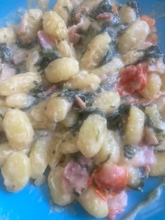 Una foto de Ñoquis con queso, verdura y bacon