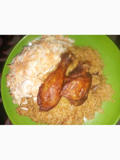 A picture of Jollof Rice, coslow and fried chicken.