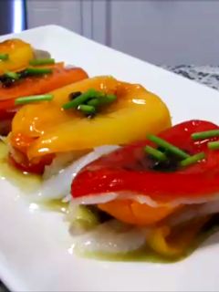 Una foto de Milhojas de pimientos tricolor y bacalao con salsa de aceitunas negras
