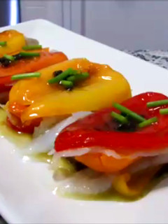 Una foto de Milhojas de pimientos tricolor y bacalao con salsa de aceitunas negras