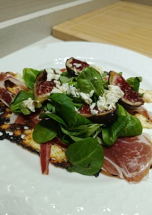 Una foto de Idea de cena saludable: Falsa pizza de queso cottage, jamón ibérico, rúcula, higos y feta