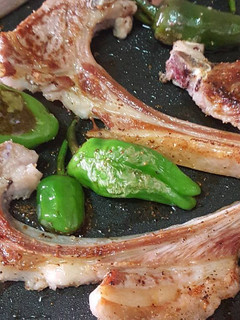 Una foto de Costilla de cordero a la plancha acompañado con pimiento