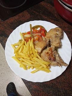 Una foto de Muslos de pollo en escabeche con papas fritas