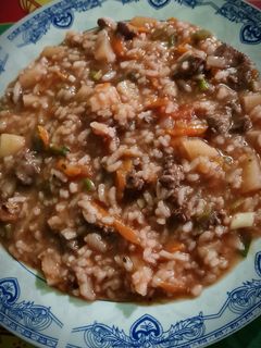 Una foto de Guiso de carne, arroz, verduras y vino tinto
