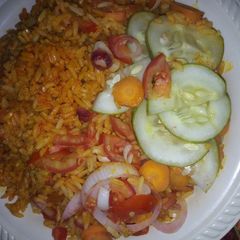 Jollof rice with caron cucumber onio frest tomatos dry fish A picture of Jollof rice with caron cucumber onio frest tomatos dry fish.