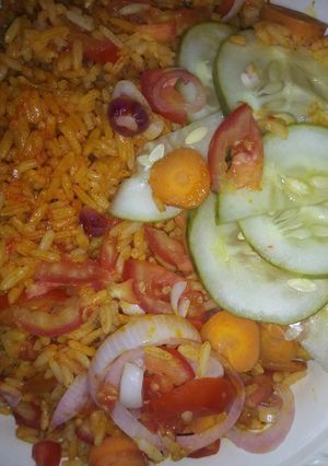 A picture of Jollof rice with caron cucumber onio frest tomatos dry fish.