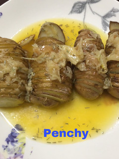 Una foto de Patatas hasselback asadas con ajos confitados y mantequilla