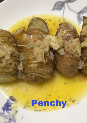 Una foto de Patatas hasselback asadas con ajos confitados y mantequilla