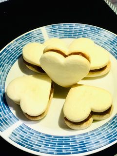 Una foto de Alfajores (maicena) con forma de corazón ❤️ de dulce de leche ❤️