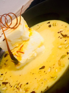 A picture of Bhapa Sandesh or steamed sandesh dipped in Rabdi.
