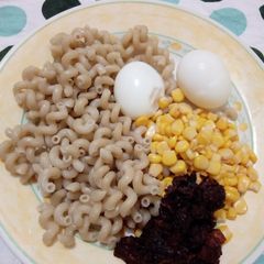 A picture of Macaroni with pepper sauce with sweetcorn and boiled egg.