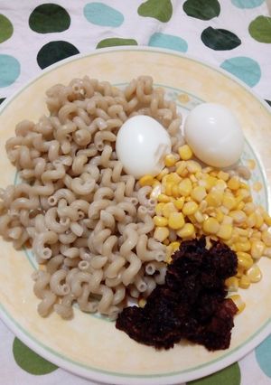 A picture of Macaroni with pepper sauce with sweetcorn and boiled egg.