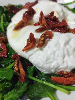 Una foto de Burrata con espinacas y tomate seco
