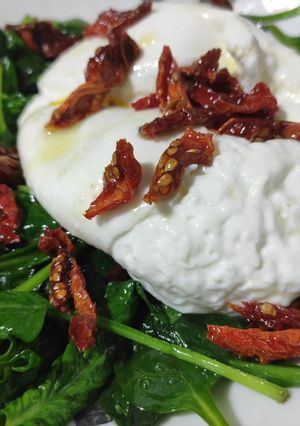 Una foto de Burrata con espinacas y tomate seco