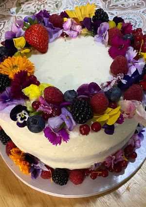 Una foto de Layer Cake con Buttercream de Queso y Fresas frescas, decorada con flores comestibles !!!!!