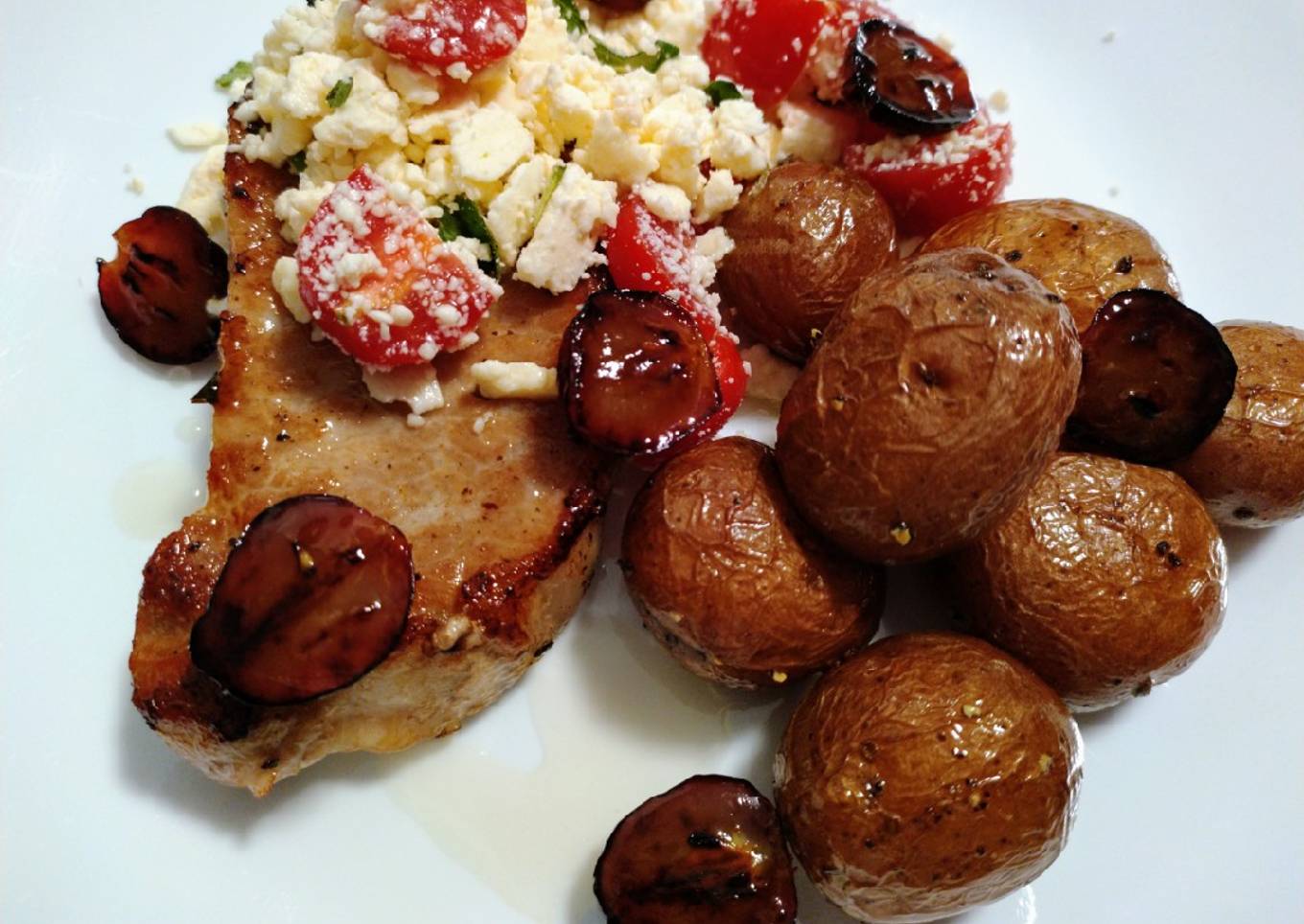Baked pork chop, feta, tomato, honey, truffled potatoes & grapes