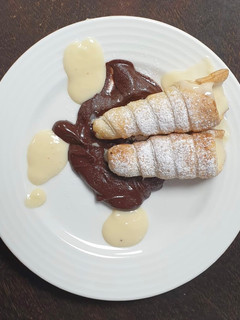 Una foto de Canutillos con cama de chocolate y crema pastelera