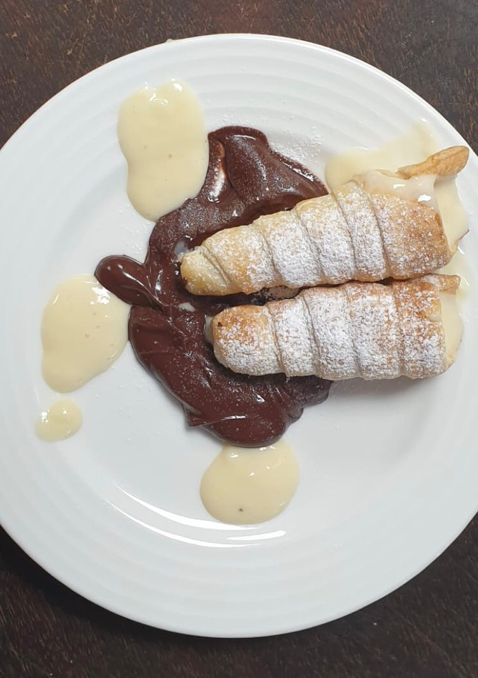 Una foto de Canutillos con cama de chocolate y crema pastelera