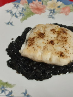 Una foto de Cola de merluza a la plancha con salsa de tinta de sepia