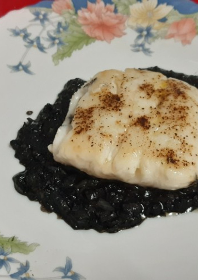 Una foto de Cola de merluza a la plancha con salsa de tinta de sepia