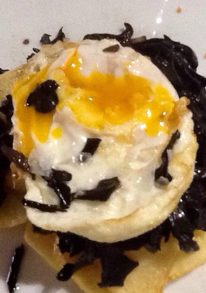 Una foto de Huevo frito con trompetas de los muertos y patatas confitadas 