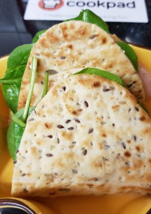 A picture of Flat multiseed Bread, with Ham,Spinach, Tomato & Soft Cheese.