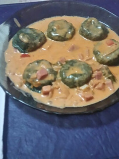 Una foto de Sorrentinos de espinaca rellenos con jamón y queso con salsa