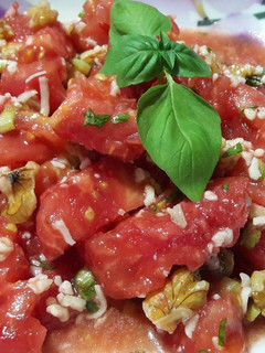 Una foto de Ensalada de tomate, nueces, ajos tiernos y albahaca