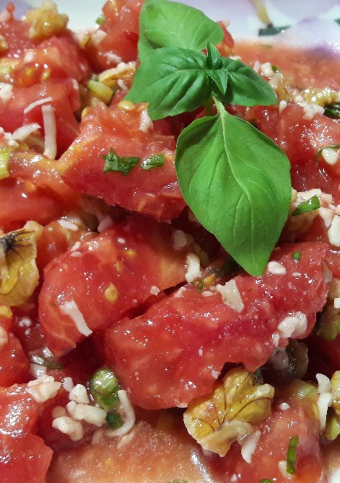 Una foto de Ensalada de tomate, nueces, ajos tiernos y albahaca