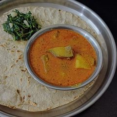 A picture of Jowar Bhakri with brinjal potato vegetable curry.