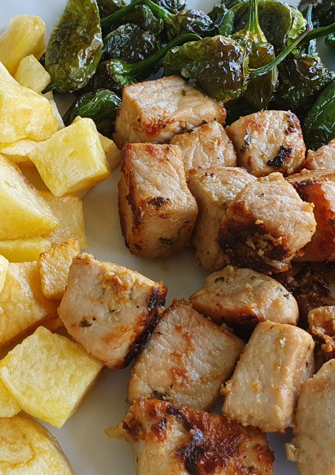 Una foto de "Raxo a Galega" con pimientos de Padrón y patatas fritas