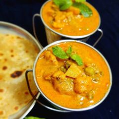 A picture of Vegetable kurma in pressure cooker.
