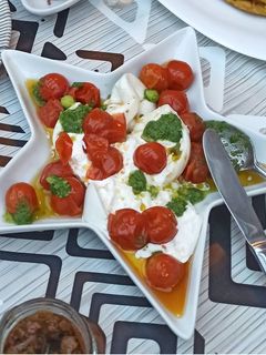 Una foto de Tomates Cherry confitados con burrata y pesto
