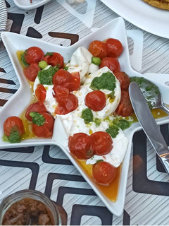 Una foto de Tomates Cherry confitados con burrata y pesto