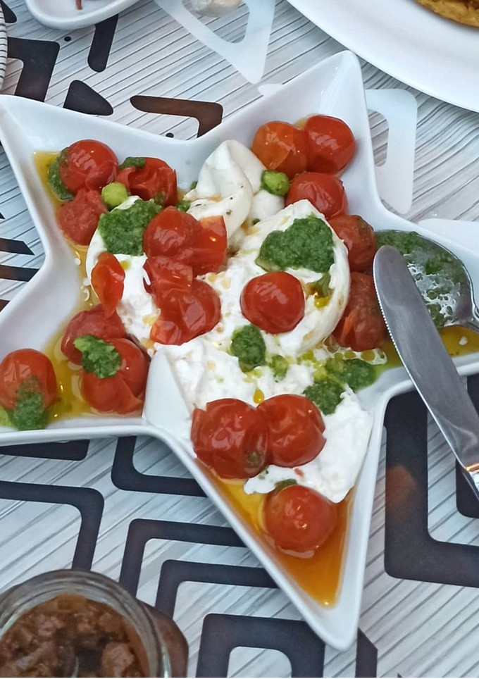 Una foto de Tomates Cherry confitados con burrata y pesto