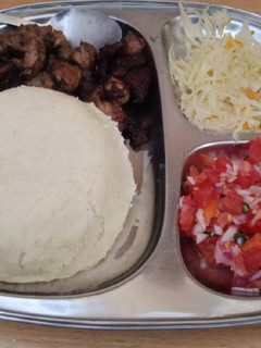 A picture of Fried Pork Ugali and cabbage and Kachumbari.