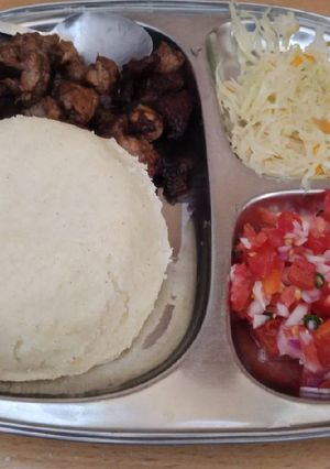 A picture of Fried Pork Ugali and cabbage and Kachumbari.