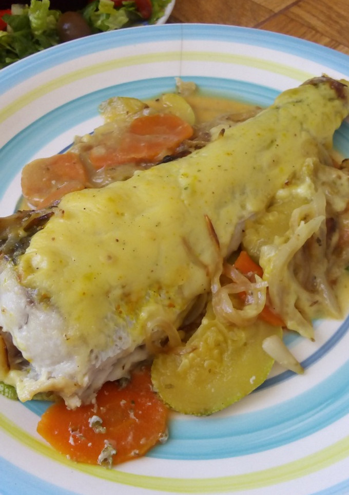 Una foto de Merluza al horno en cama de zanahoria, zapallitos y cebolla caramelizada