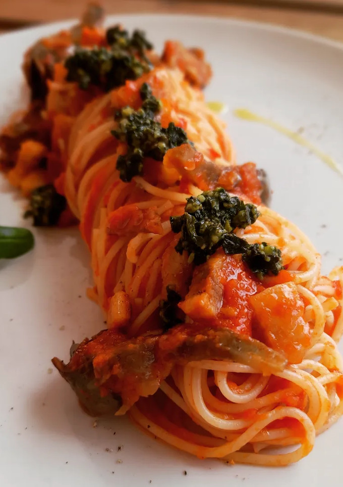 Una foto de Espaguetis amatriciana con alcachofa y albahaca con parmesano