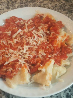 Una foto de Ñoquis caseros con tomate y carne con queso parmesano