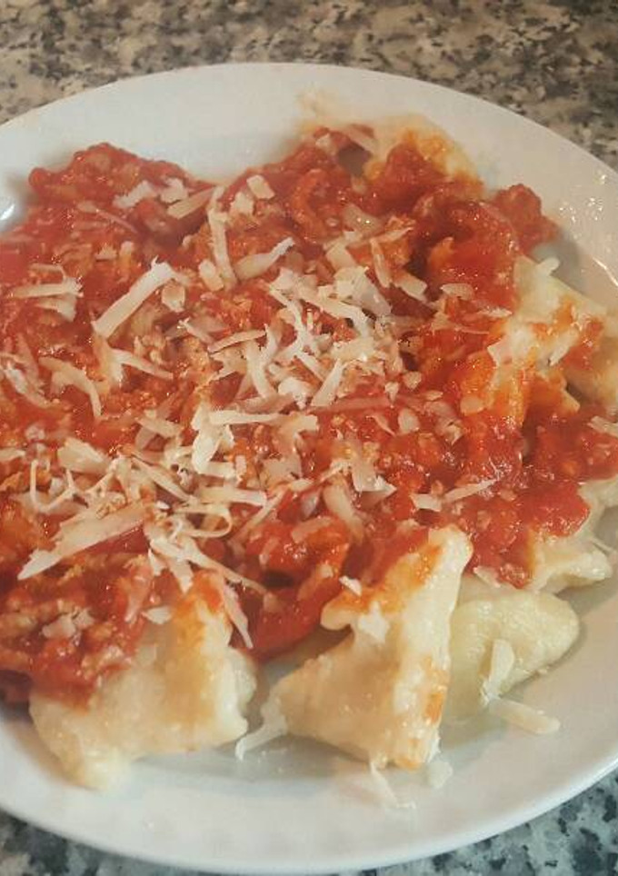Una foto de Ñoquis caseros con tomate y carne con queso parmesano