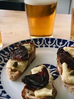 Una foto de Tosta de queso curado con ciruela deshidratada y alcaparras