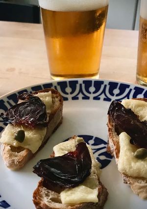 Una foto de Tosta de queso curado con ciruela deshidratada y alcaparras