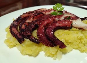 Foto di Tentacoli di Polpo con Salsa Vinaigrette serviti su Letto di Patate