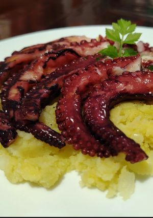 Foto di Tentacoli di Polpo con Salsa Vinaigrette serviti su Letto di Patate