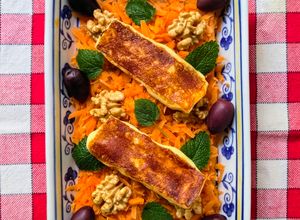 Una foto de Queso Halloumi grillado, sobre colchón de zanahoria con nueces, menta y aceitunas Kalamata 🧀🫒🥕🌱