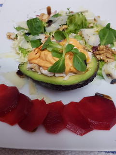 Una foto de Aguacate relleno de pollo, salsa rosa, ensalada y carpaccio de ciruela