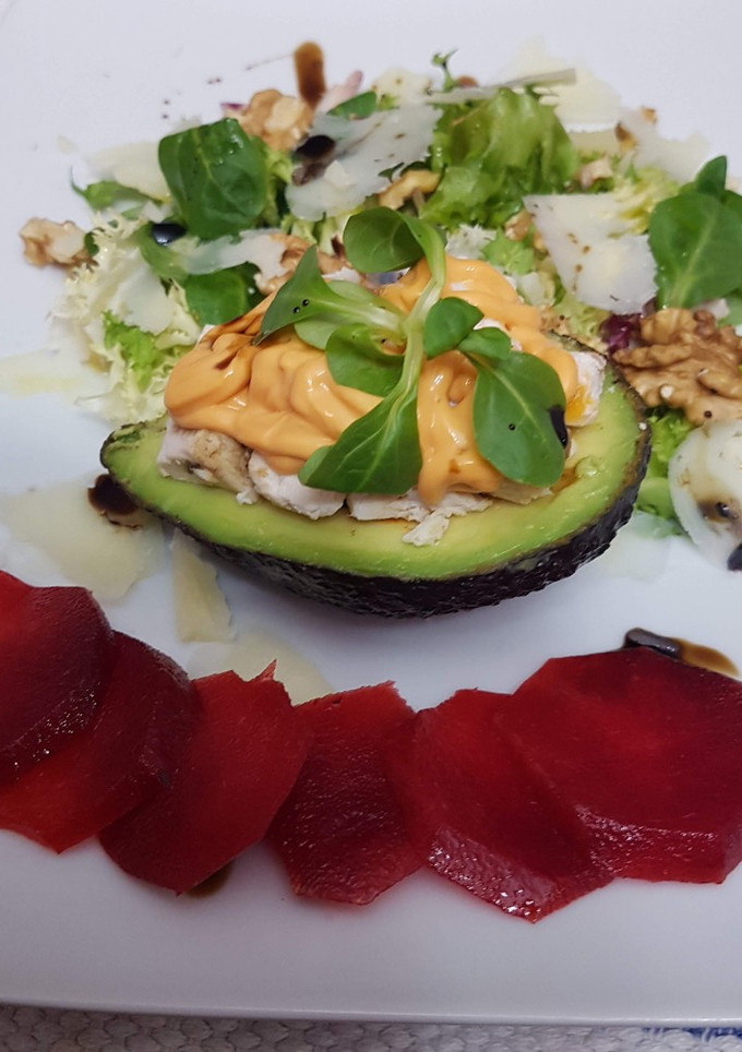 Una foto de Aguacate relleno de pollo, salsa rosa, ensalada y carpaccio de ciruela